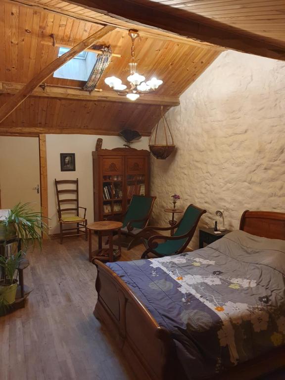 1 dormitorio con 1 cama, mesa y sillas en Chambre d’hôtes de Vauguenige, en Saint-Pardoux
