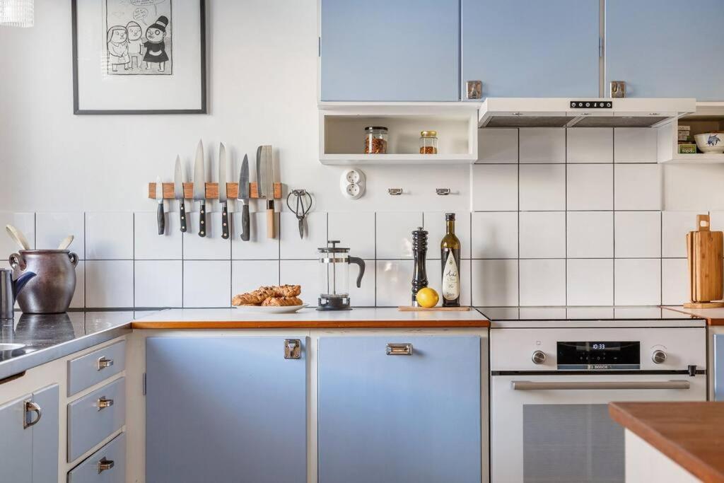 a kitchen with white cabinets and white appliances at Retro Retreat with Modern Comforts in Stockholm