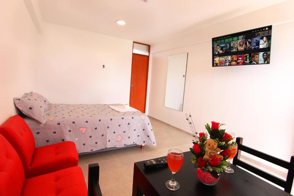 a living room with a red chair and a table at Palacio del Sur in Lurín