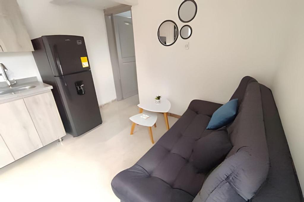 a living room with a couch and a refrigerator at GURUS FR | Apartamento Central Cerca al estadio y aeropuerto in Pereira