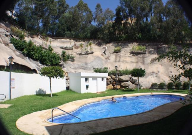 a large swimming pool in front of a rock wall at Oasis 4 - Mojacar - Sleeps 4 in Mojácar