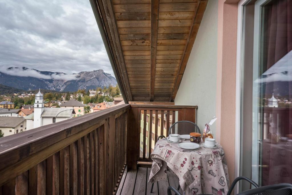 d'une table sur un balcon avec vue sur la montagne. dans l'établissement Giongo Residence Aparthotel 202, à Lavarone