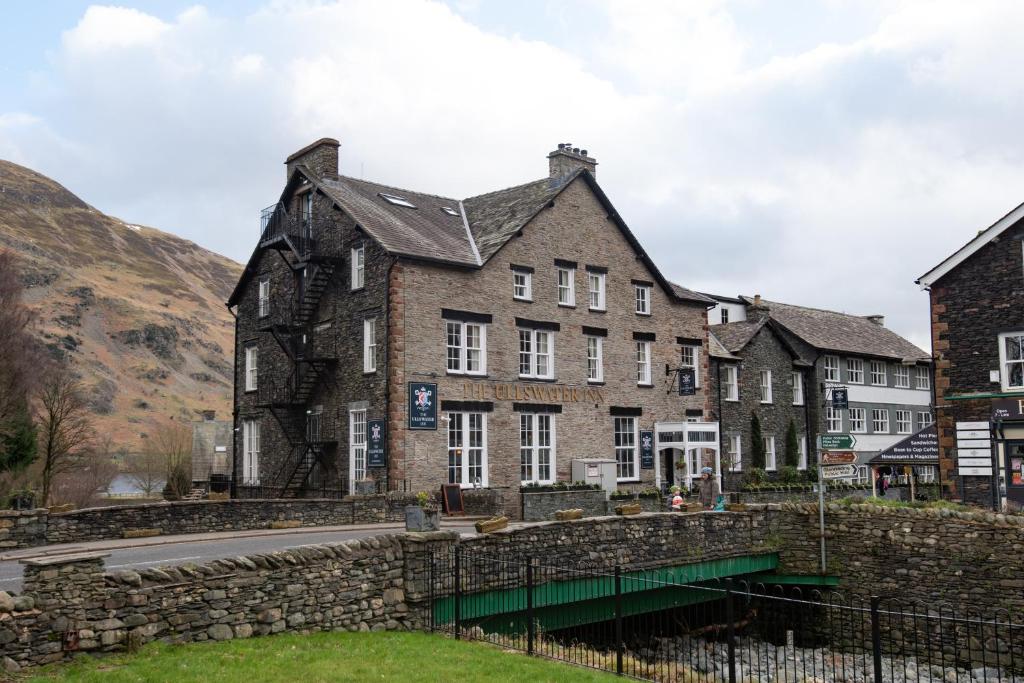 格倫里丁的住宿－The Ullswater Inn- The Inn Collection Group，道路一侧的旧建筑