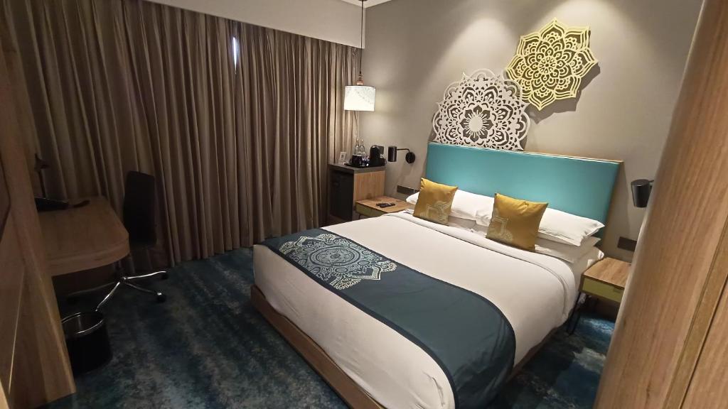een slaapkamer met een groot bed met een blauw hoofdeinde bij Jupiter Gold Delhi Airport in New Delhi