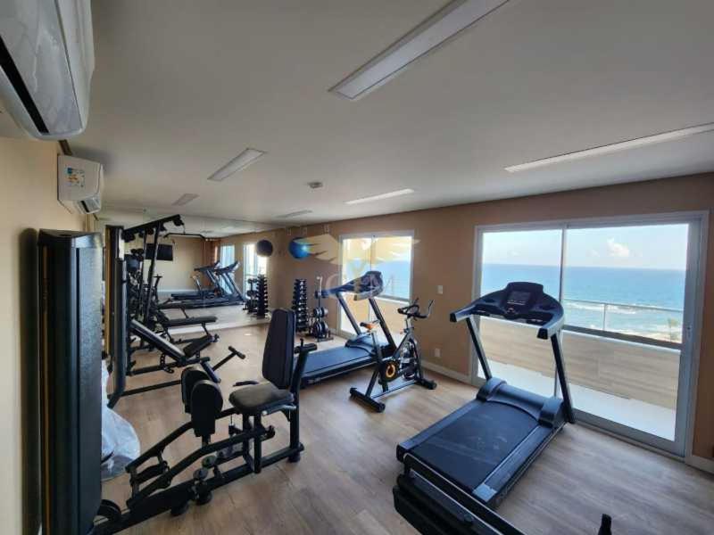 a gym with several tread machines in a room with the ocean at Flat Lindíssimo Beira-Mar in Salvador