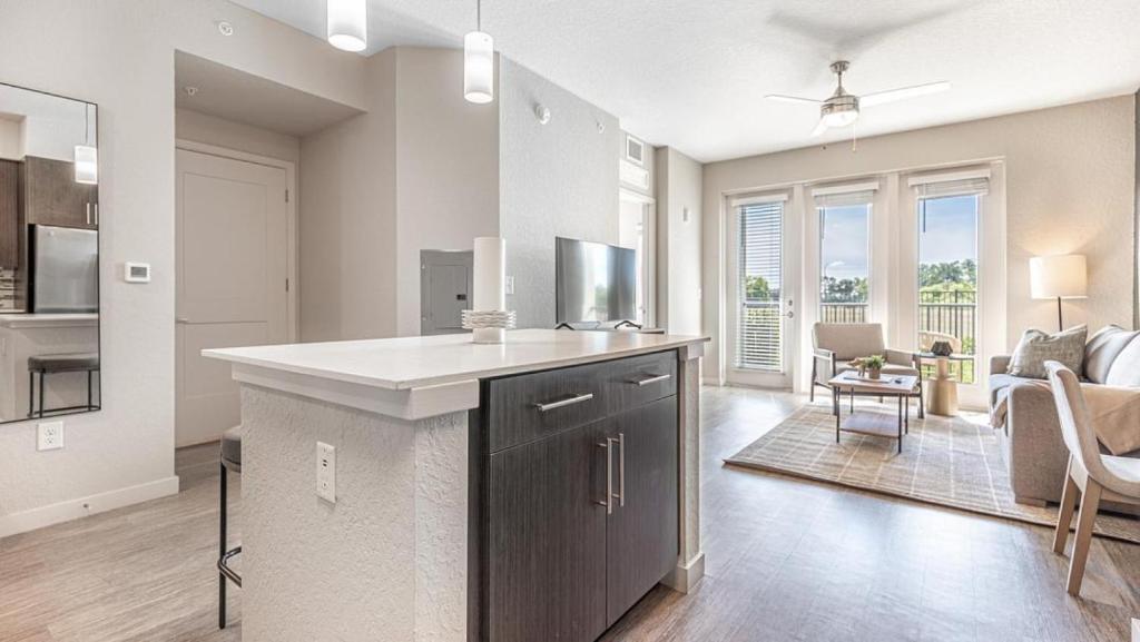 uma cozinha com um balcão e uma sala de estar em Landing Modern Apartment with Amazing Amenities (ID8083X42) em Fort Myers Villas