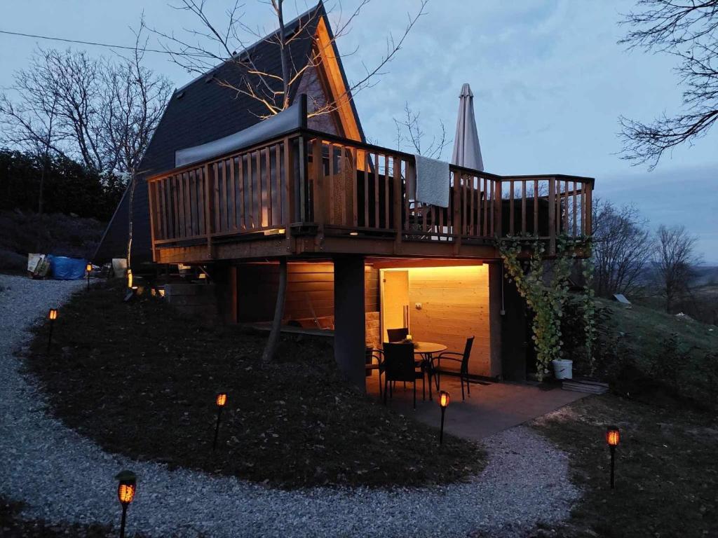 une cabane dans les arbres avec une terrasse au-dessus dans l'établissement Glamping Holiday House with hot tub and sauna- Hisa oddiha, à Smarjeske Toplice