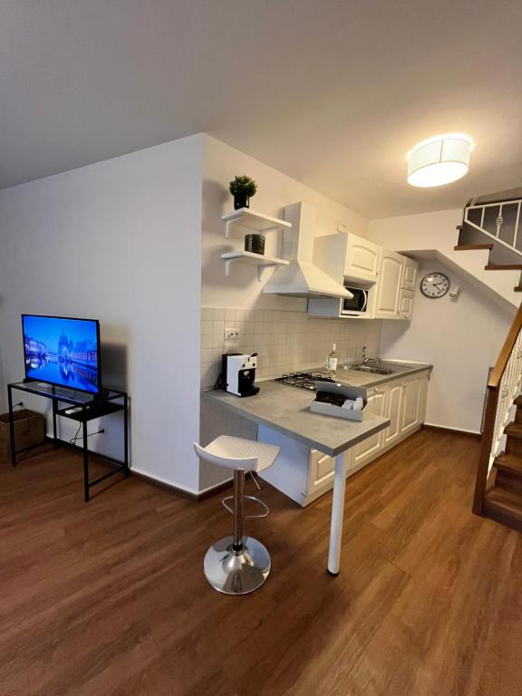a kitchen with white cabinets and a table and a television at Gaiola N 7 in Naples