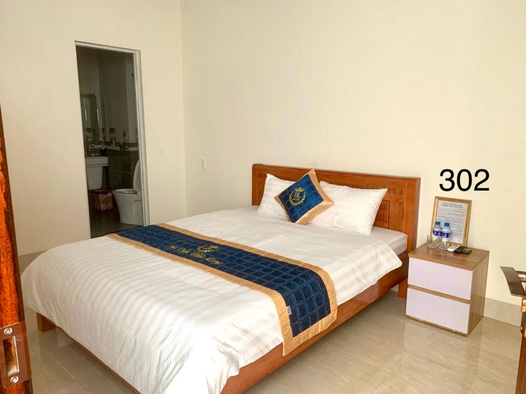 een slaapkamer met een bed met een blauwe en witte deken bij Bảo Long Motel in Dồng Văn