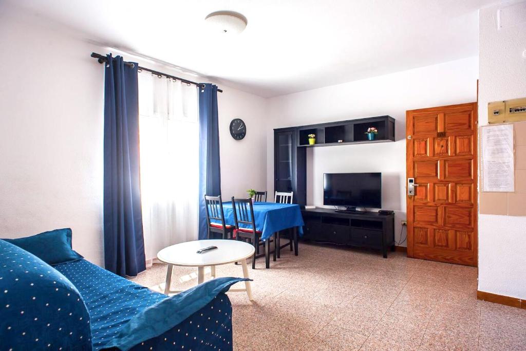 ein Wohnzimmer mit einem blauen Sofa und einem Tisch in der Unterkunft 2 bedrooms appartement with wifi at Las Palmas de Gran Canaria in Las Palmas de Gran Canaria