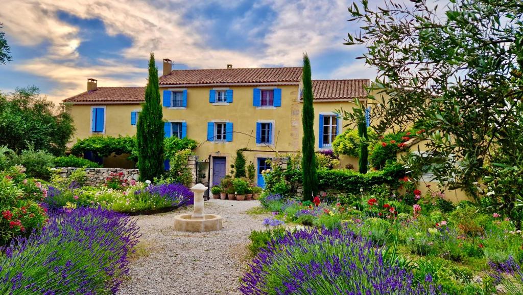 une maison avec un jardin planté de fleurs et d'arbres dans l'établissement Bastide Saint-Didier, à Saint-Didier