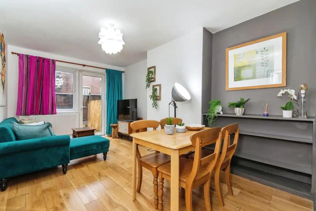 a living room with a table and a green couch at City-Accessible 1-Bed Apartment in Bethnal Green in London