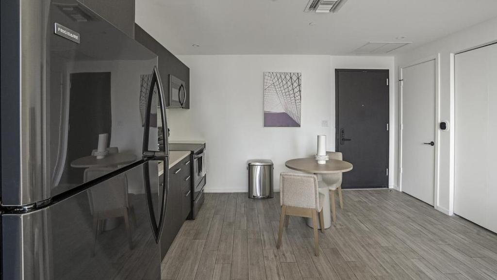 - un salon avec une table et un réfrigérateur dans l'établissement Landing - Modern Apartment with Amazing Amenities (ID1401X723), à Fort Lauderdale