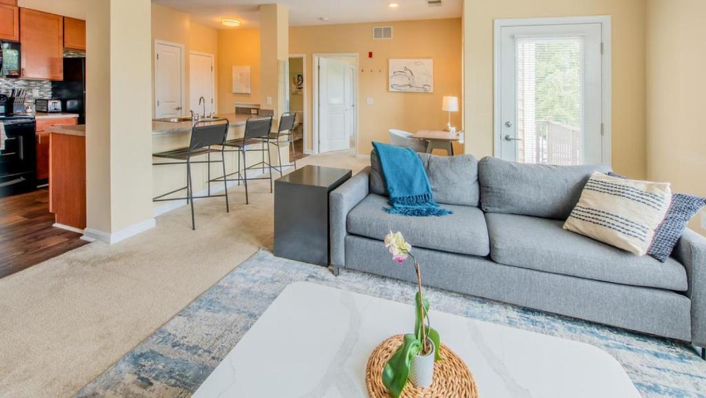 een woonkamer met een bank en een keuken bij Landing Modern Apartment with Amazing Amenities (ID2284) in Ellicott City