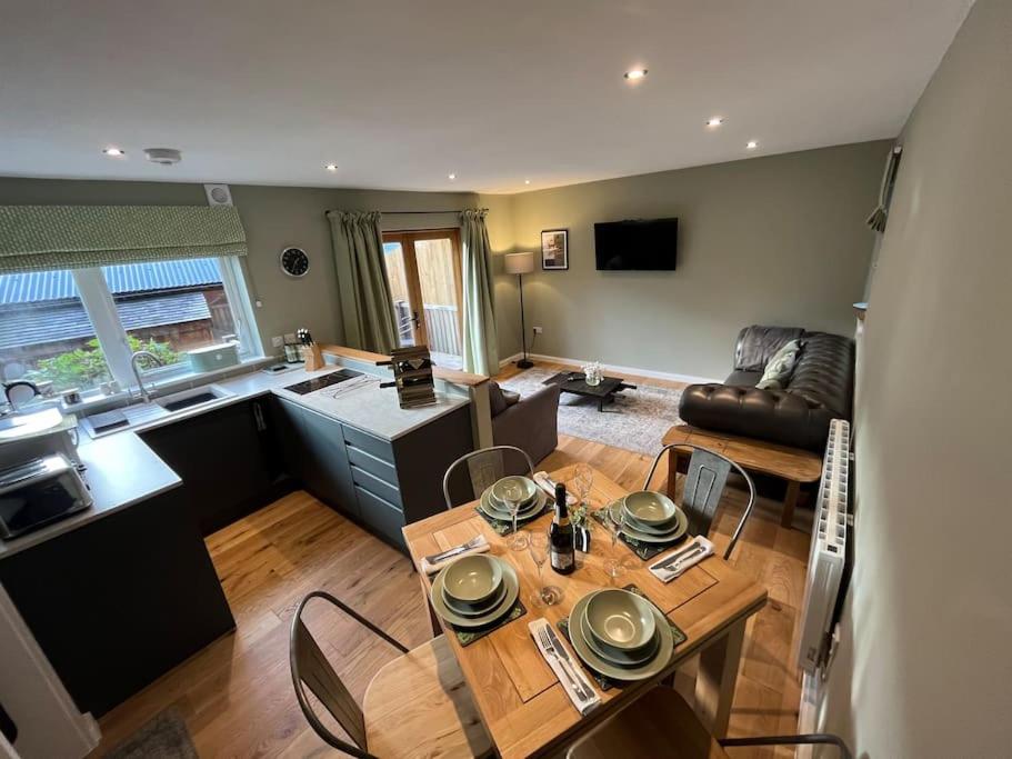 a kitchen and living room with a table and chairs at The Poplars - Cosy Modern Flat with Great Networking in Telford