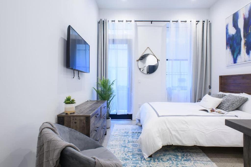 um quarto com uma cama, uma televisão e um sofá em 3-2 NEW Prime E Village Private outdoor! em Nova Iorque