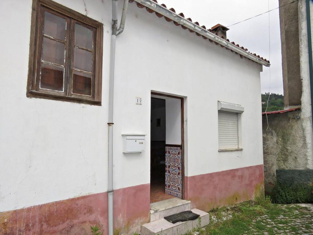 Casa blanca con puerta y ventana en One bedroom house with terrace and wifi at Miranda do Corvo, en Vale de Colmeias