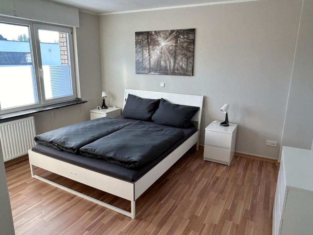 a bedroom with a bed and two night stands at Ferienwohnung Hommelshof in Korschenbroich