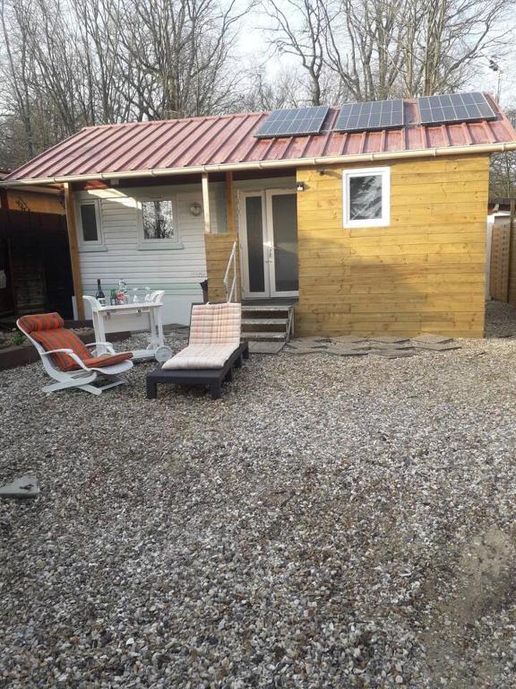une petite maison avec des panneaux solaires sur le toit dans l'établissement Chalet charmant aux Bréviaires avec terrasse et barbecue, à Les Bréviaires