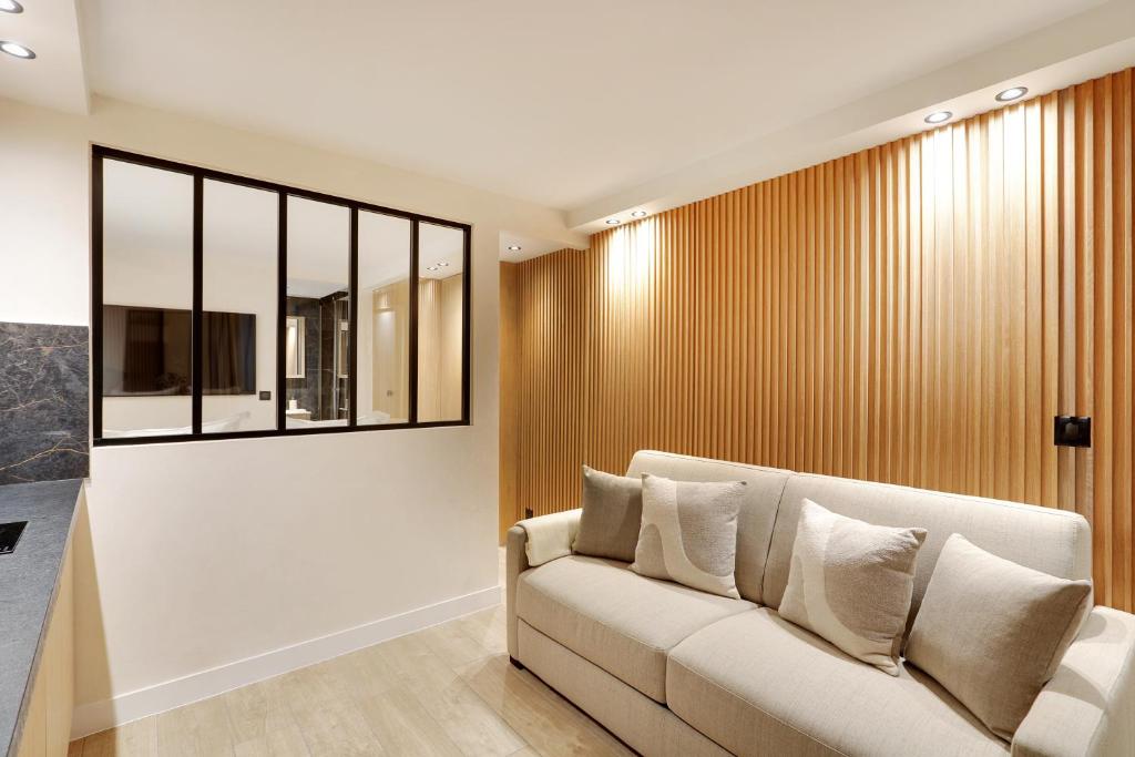 un salon avec un canapé et une fenêtre dans l'établissement Pick A Flat's Apartment in Odeon - Rue Saint André des Arts, à Paris