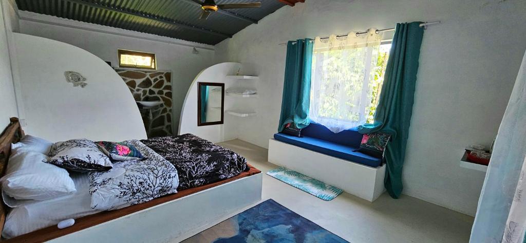 um quarto com uma cama e uma janela em Le lataniers em Rodrigues Island