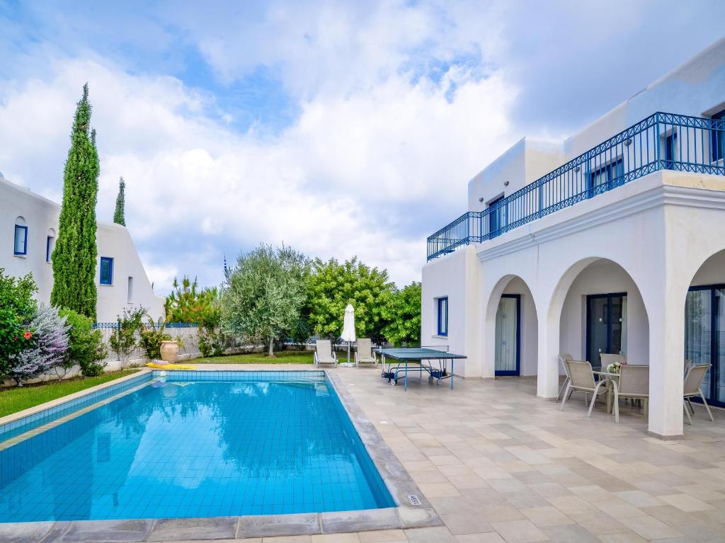 a villa with a swimming pool and a patio at Azzurro Holiday Villas in Peyia