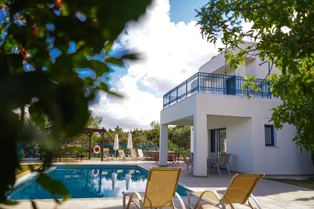 a villa with a swimming pool and a house at Azzurro Holiday Villas in Peyia