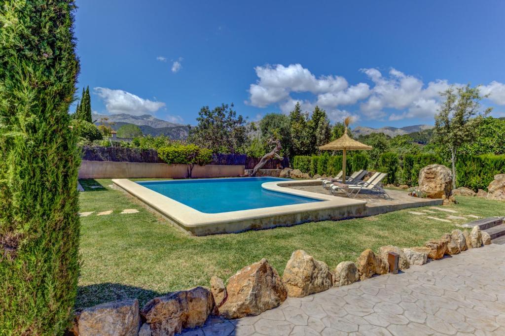 a swimming pool in a yard with a grass yard at Villa Can Martin by Sealand Villas in Pollença