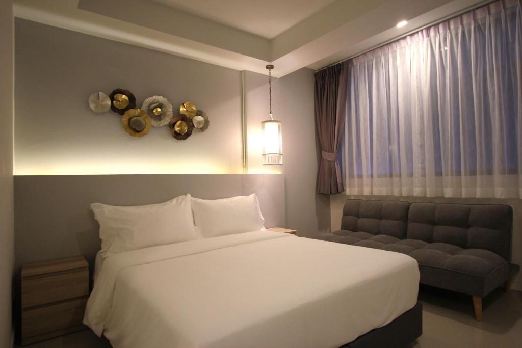 1 dormitorio con cama blanca y sofá en Kamala Havana en Kamala Beach