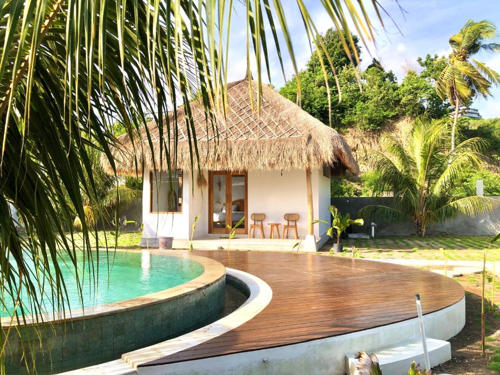 a resort with a swimming pool and a house at Luana Lombok in Selong Belanak