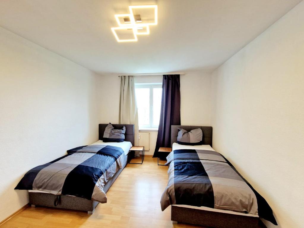 1 dormitorio con 2 camas y ventana en 2 bedrooms appartement with balcony and wifi at Auerbach Bensheim 
