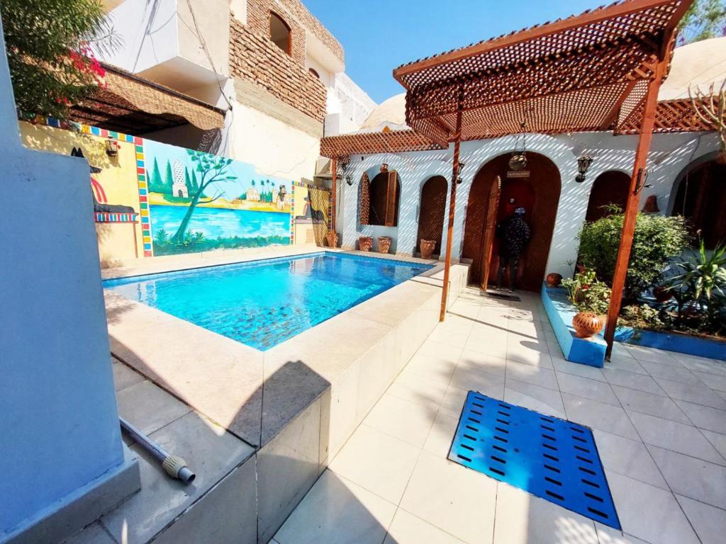 a swimming pool in front of a house at Villa Cleopatra Luxor west bank in Luxor