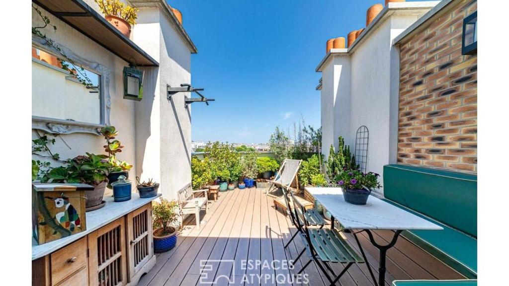 a balcony with a table and chairs on a building at Paris Best view w/Rooftop! in Paris