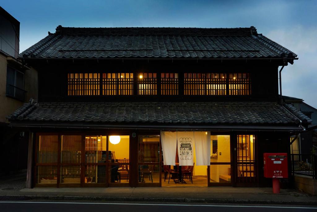 um edifício com uma mesa e cadeiras em frente em 結家 -MUSUBIYA- em Kawagoe