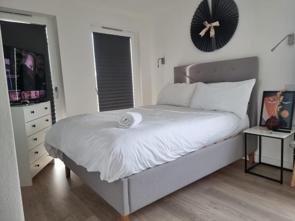 een slaapkamer met een bed met een klok aan de muur bij Beckenham- Stunning Double Bedroom With En-suite in SHARED APARTMENT in Elmers End