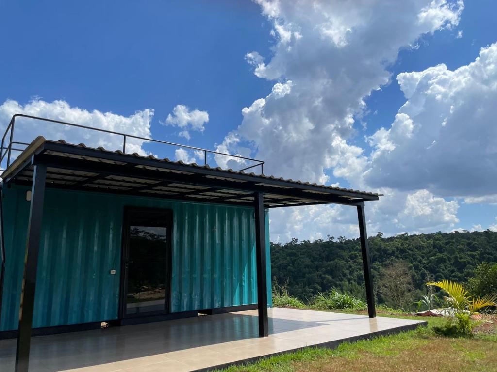 a green building with a roof on a deck at Container Home Py in Puerto Presidente Franco