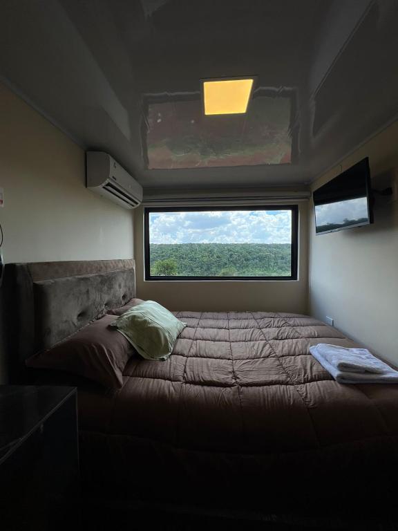 a bed in a small room with a window at Container Home Py in Puerto Presidente Franco