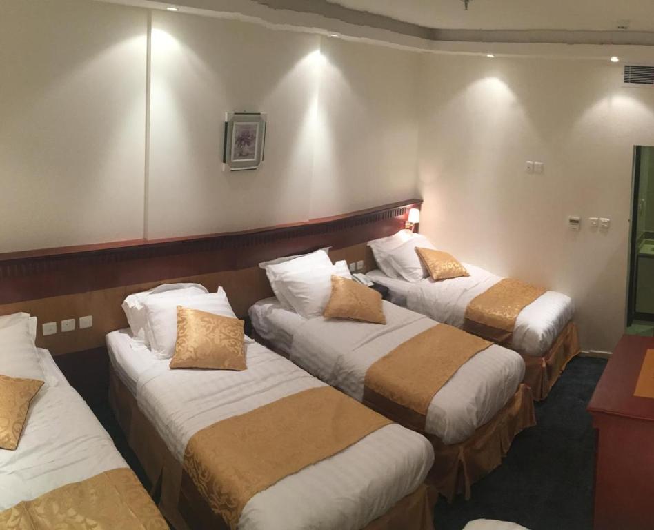 a room with three beds in a room at Al Adl Jewel Hotel in Mecca