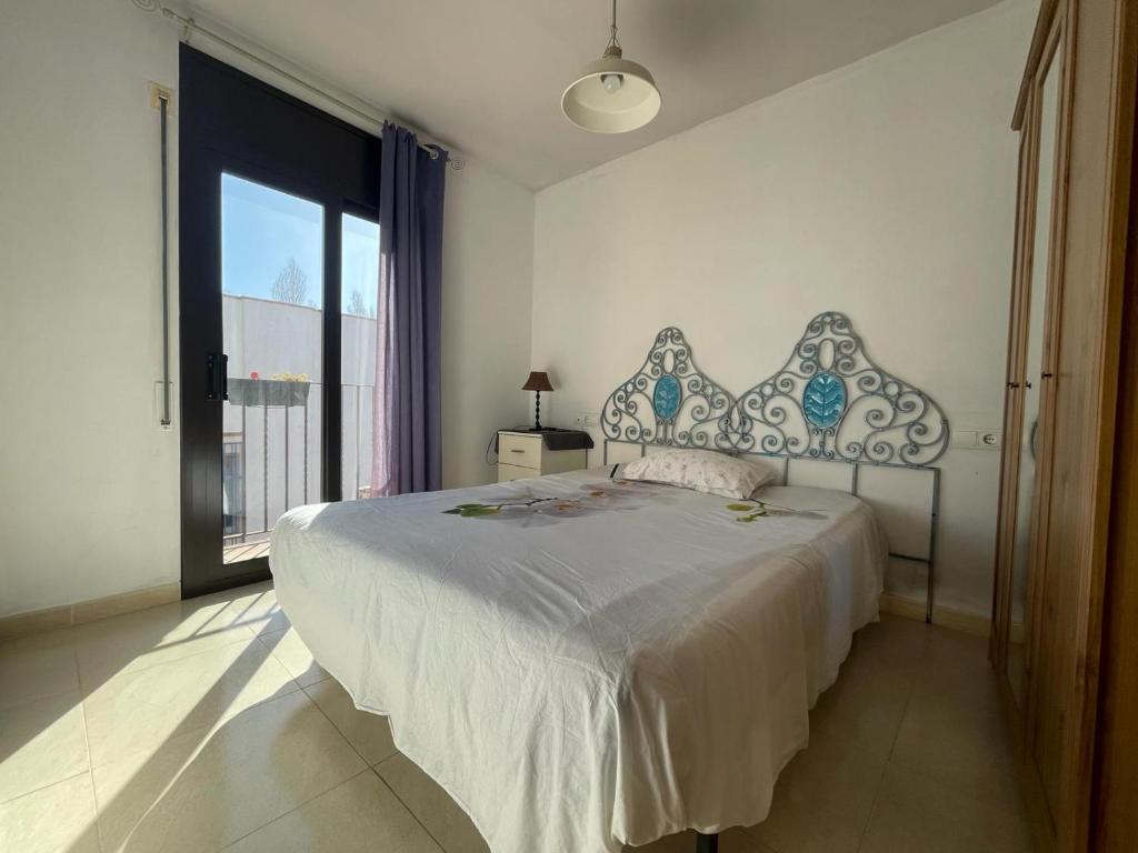 a bedroom with a large bed and a large window at 1 La Cala Palamós in Palamós