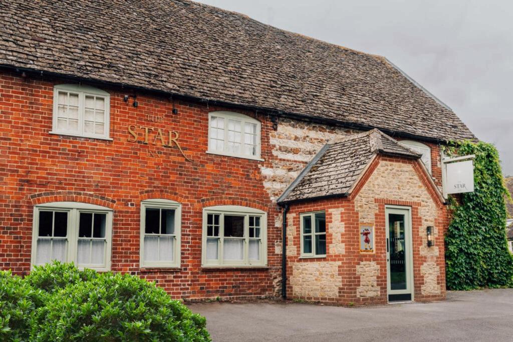 ein rotes Backsteingebäude mit weißen Fenstern darauf in der Unterkunft The Sparsholt Barn in Wantage