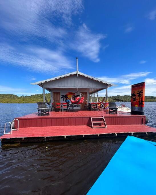 a red dock with a building on the water at Flutuante Long Beach Manaus Am in Manaus
