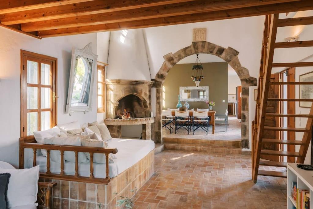 a living room with a bed and a fireplace at Villa Margarita - Ampia villa situated in Lardos in Lardos