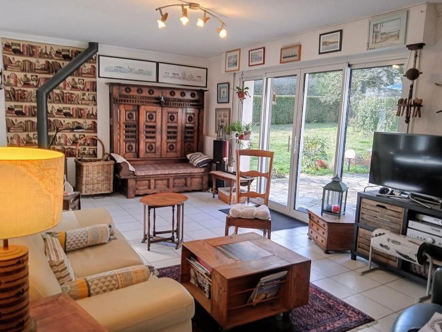 Una sala de estar con un sofá y un televisor. en Ty Clafout Vannetaise parking wifi linge non inclus, en Saint-Nolff