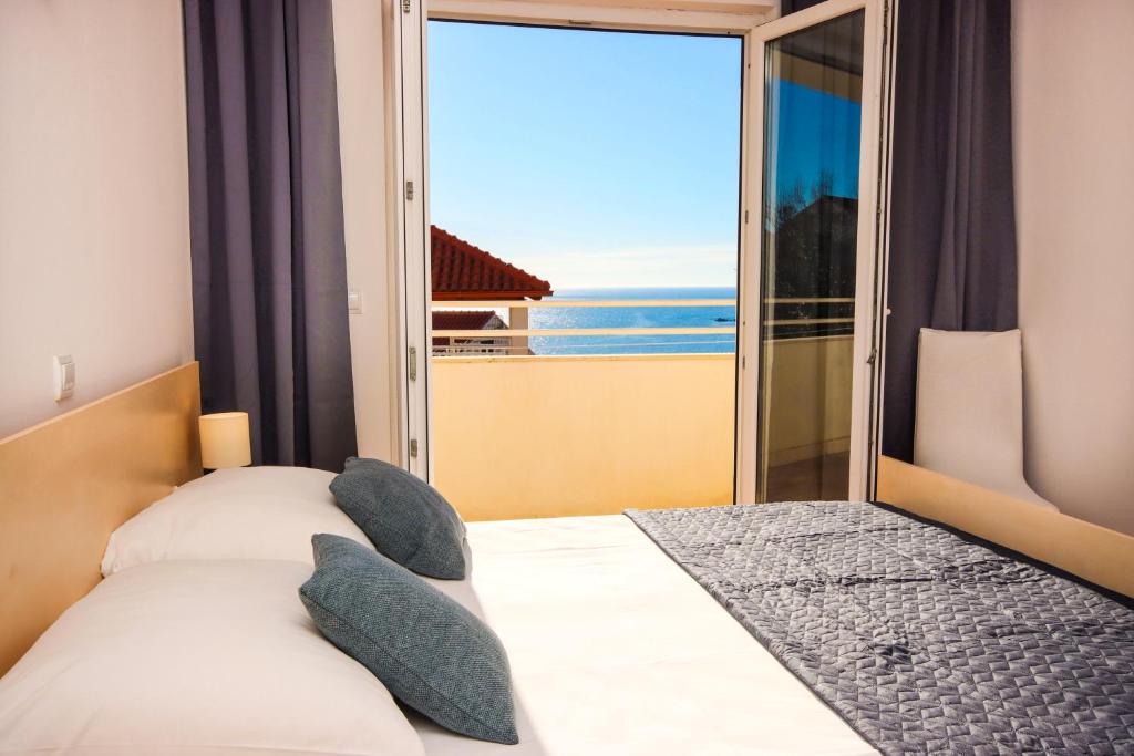 1 dormitorio con 2 camas y vistas al océano en Apartments Mira, en Cavtat