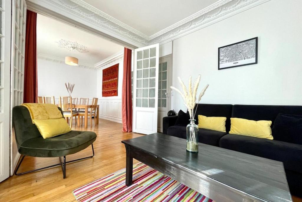 un soggiorno con un divano e un tavolo di 20min de Paris - Chez Daniel a Villemomble