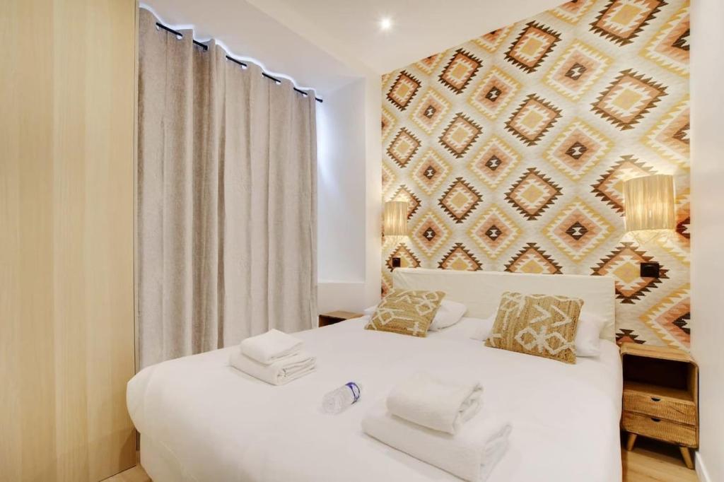 une chambre avec un lit blanc avec des serviettes dessus dans l'établissement Place d'Italie Modern & Renovated 3BD for 10guests, à Paris