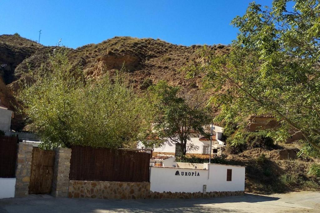 a building with a fence in front of a mountain at 3 bedrooms property with private pool at Cortes y Graena in Graena