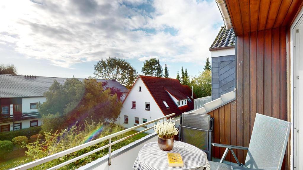 einen Balkon mit einem Tisch und einer Vase aus Blumen in der Unterkunft NeuKlosterhof App. 23 in Pelzerhaken
