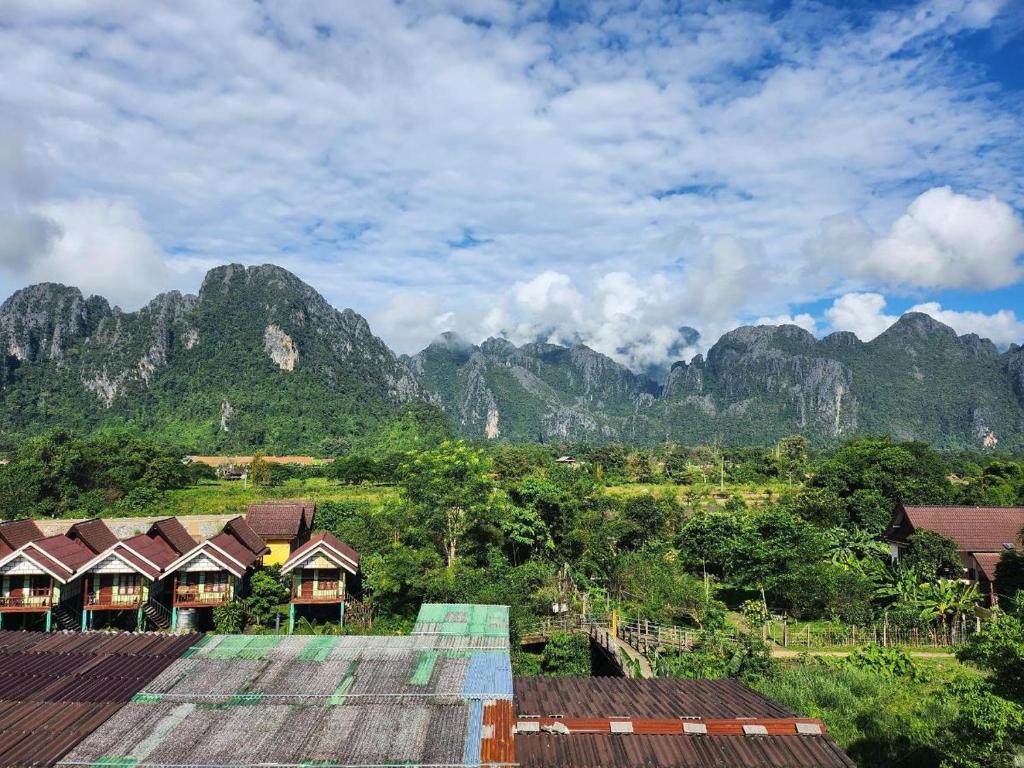 a view of a mountain range with houses and trees at Vang Vieng Sky Mountain View Hotel in Vang Vieng