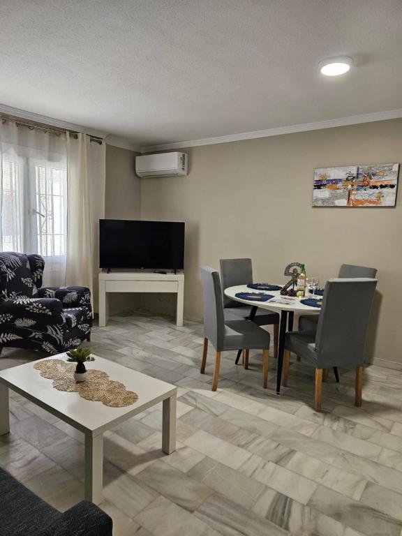 sala de estar con mesa, sillas y TV en APARTAMENTO VERA COAST 123, en Playas de Vera